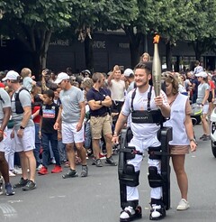 Kevin Piette, paralítico, caminha com a tocha das Olimpíadas de 2024 enquanto usa o exoesqueleto Wandercraft Atalante X. (Fonte da imagem: Jean Louis Constanza, Wandercraft) 