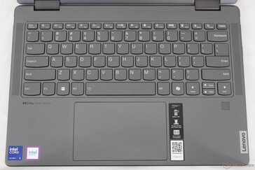 O layout do teclado inclui grades de alto-falante nas laterais, enquanto o Yoga 9 2 em 1 14 inclui teclas auxiliares extras